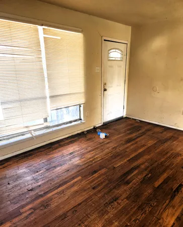 a view of a room with wooden floor and window