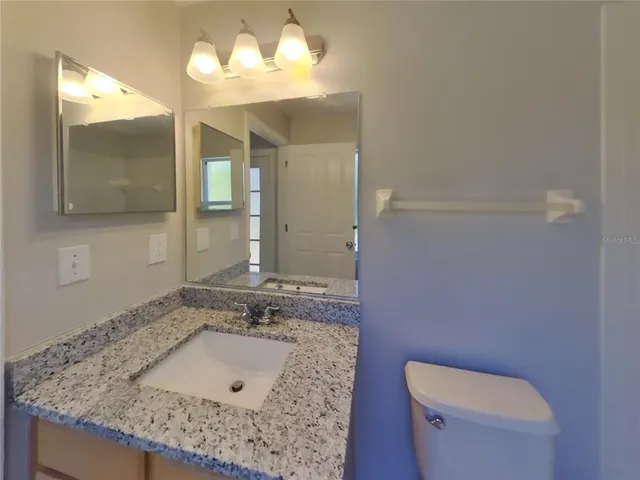 a bathroom with a sink a toilet and mirror