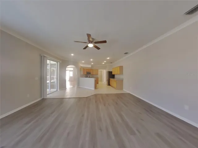 a view of an empty room with window and wooden floor