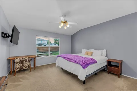 a spacious bedroom with a bed and a chandelier