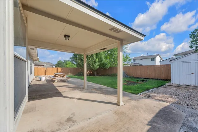 a view of a patio with a table and chairs next to a yard