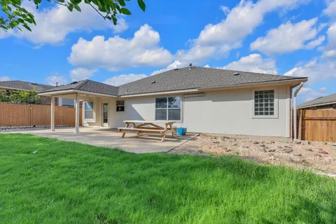 a front view of a house with patio and garden