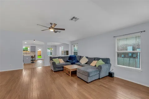 a living room with furniture and a wooden floor