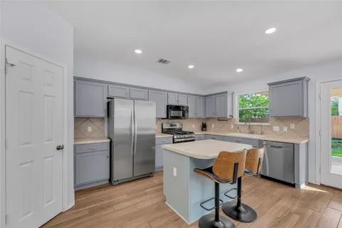 a kitchen with refrigerator and chairs