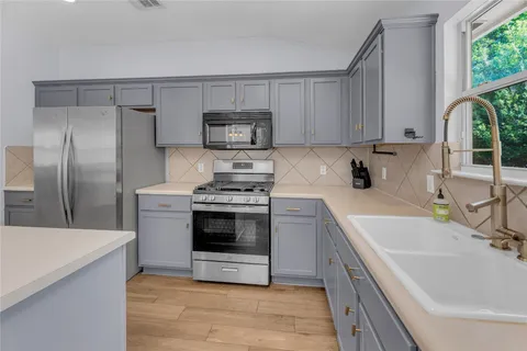a kitchen with a sink stove and refrigerator
