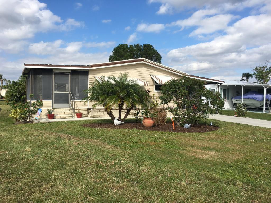 108 Audubon Road Naples, FL 34114 - Photo 2 of 11 a front view of a house with garden