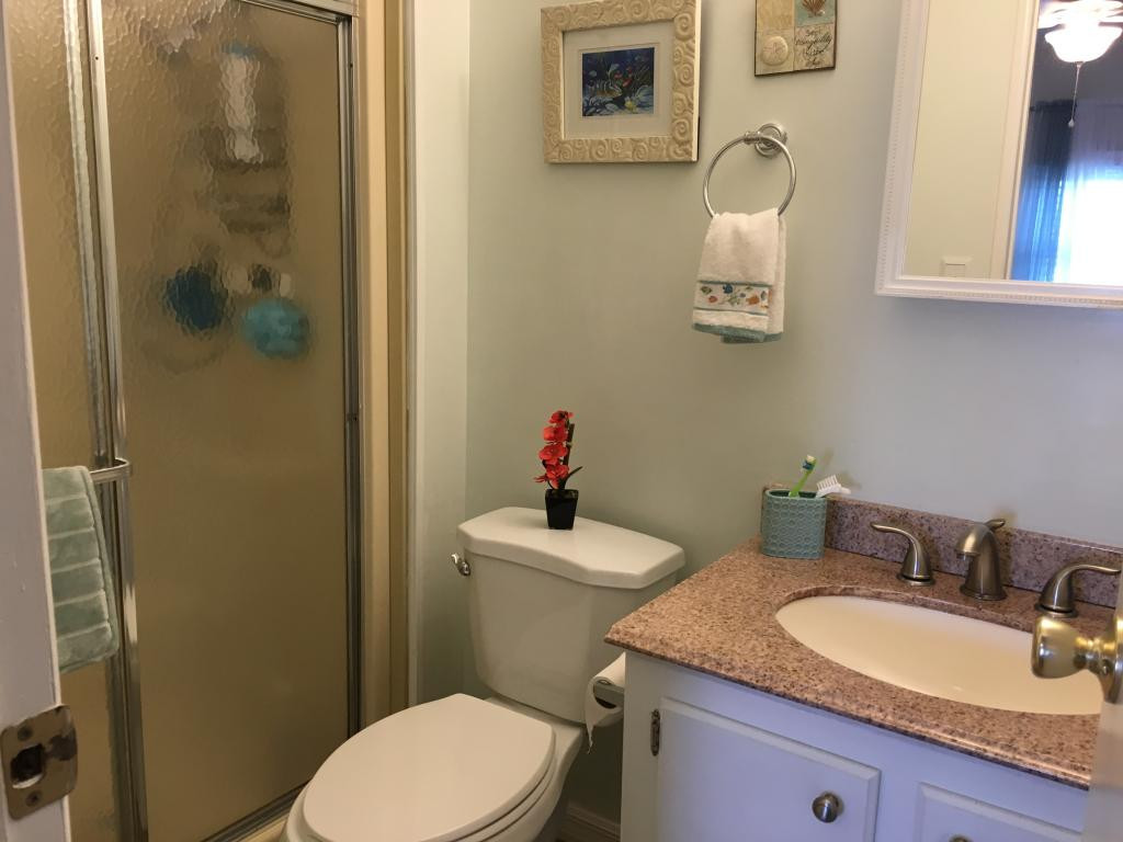 108 Audubon Road Naples, FL 34114 - Photo 8 of 11 a bathroom with a granite countertop sink a mirror and a toilet