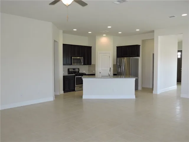 a metallic refrigerator freezer sitting inside of a kitchen