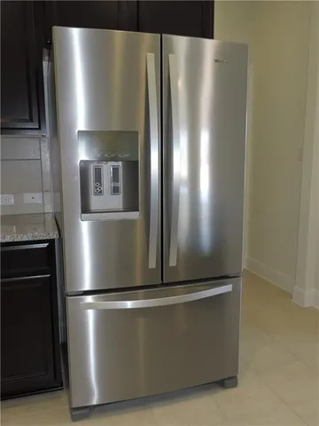 an empty room with a chandelier fan and windows