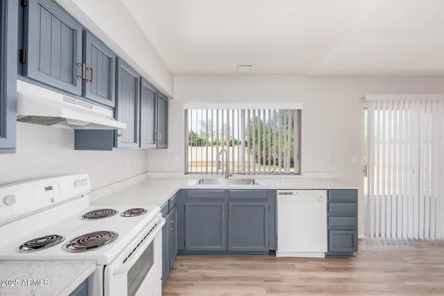 a kitchen with a sink a stove and cabinets