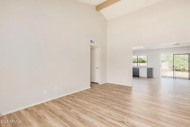 a view of empty room with wooden floor and windows
