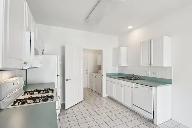 a kitchen with granite countertop a sink stove and cabinets