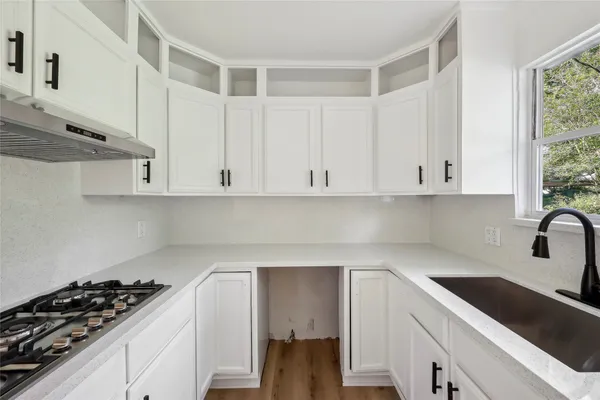 a kitchen with white cabinets and appliances