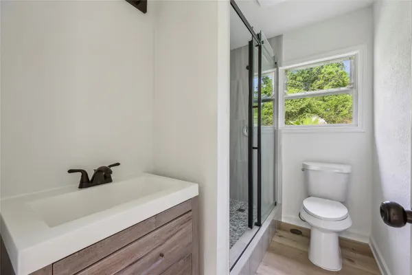 a bathroom with a sink a toilet and a shower