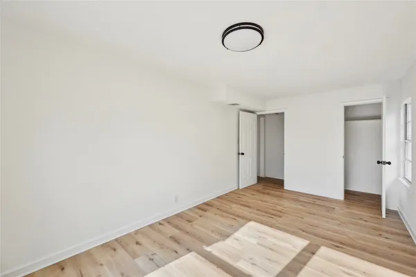 a view of a room with wooden floor and white walls