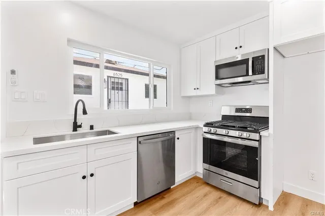 a kitchen with cabinets stainless steel appliances and a sink