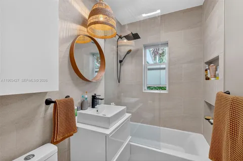 a bathroom with a sink mirror toilet and bathtub