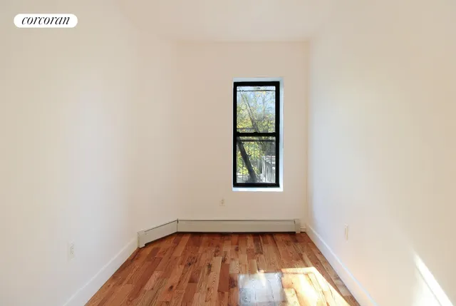 a view of a room with wooden floor and window