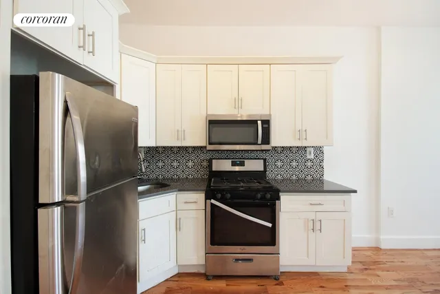 a kitchen with stainless steel appliances a refrigerator stove and microwave