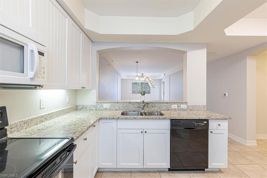 1100 Pine Ridge Road, Unit B106 Naples, FL 34108 - Photo 10 of 10 a kitchen with granite countertop a sink stainless steel appliances and cabinets