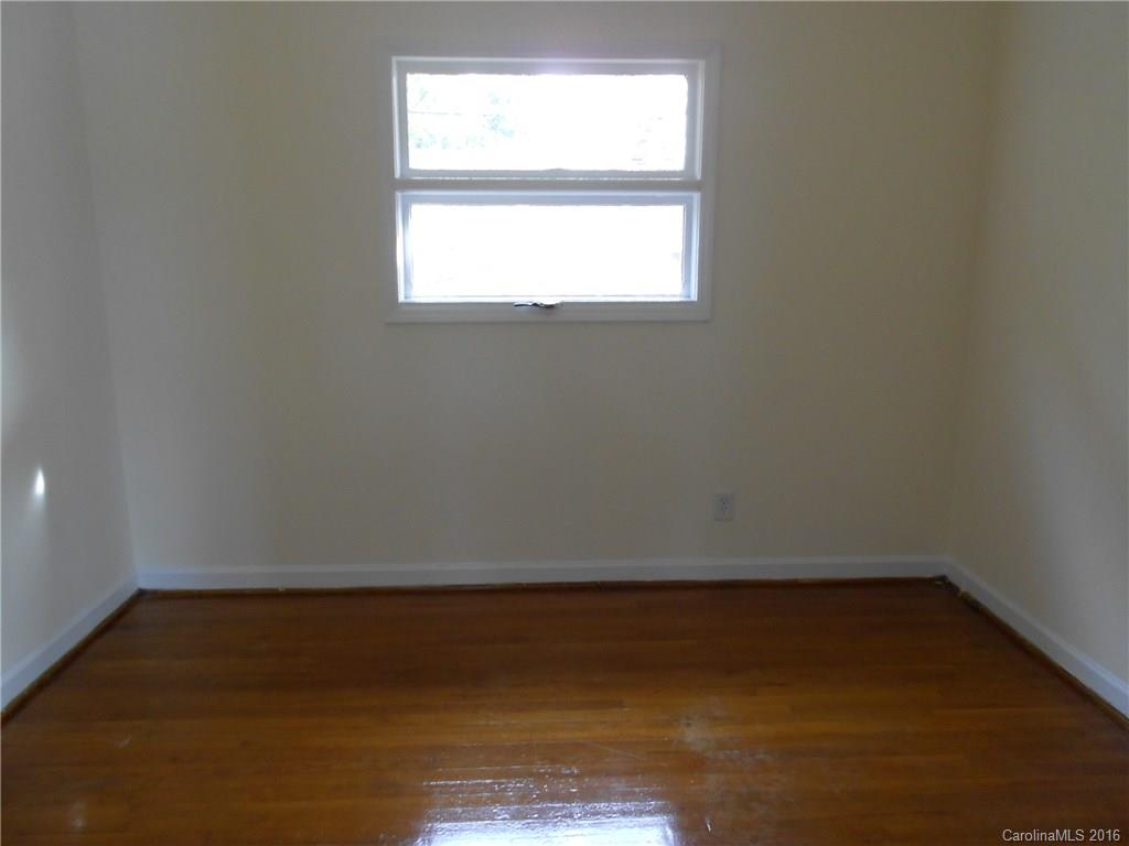3830 Tuckaseegee Road, Unit 1 Charlotte, NC 28208 - Photo 6 of 6 an empty room with wooden floor and windows