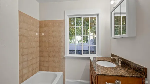 a bathroom with a granite countertop sink and a mirror