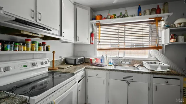 a kitchen with stainless steel appliances granite countertop a sink dishwasher stove and cabinets