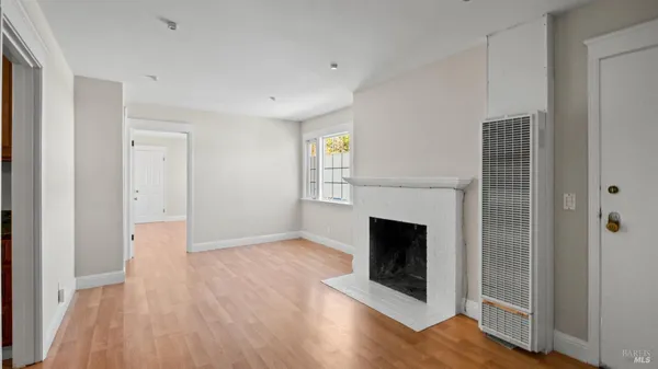 a view of a livingroom with wooden floor and a fireplace