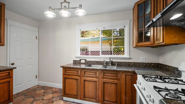 a kitchen with stainless steel appliances granite countertop a sink a stove and a microwave