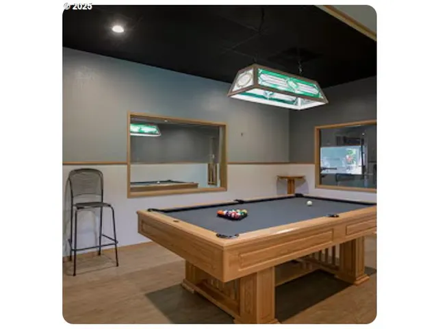 a view of kitchen with kitchen island stainless steel appliances refrigerator stove and living room