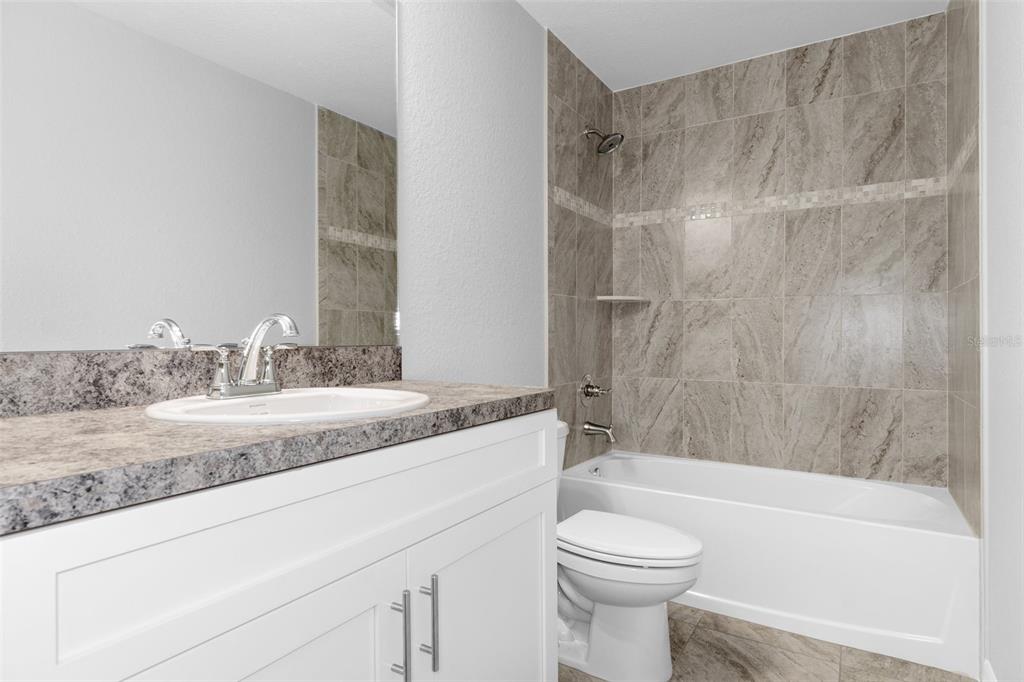 16375 Kakawi Road Brooksville, FL 34614 - Photo 24 of 30 a bathroom with a granite countertop sink toilet and shower