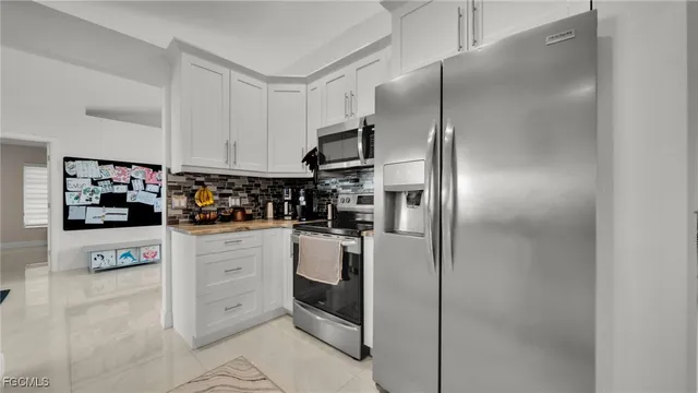a kitchen with stainless steel appliances a refrigerator sink and cabinets