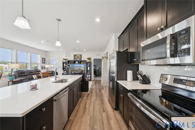 a kitchen with stainless steel appliances granite countertop a sink a stove and refrigerator