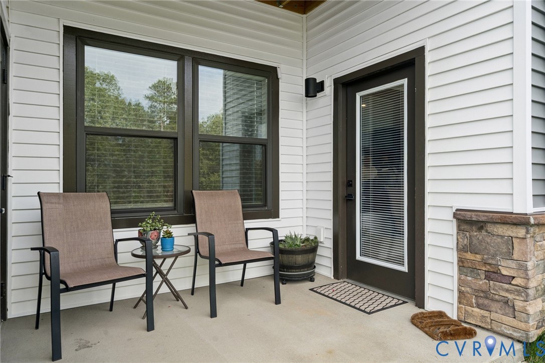 4000 Maze Runner Drive, Unit 103 Midlothian, VA 23112 - Photo 18 of 24 a balcony with table and chairs and potted plants