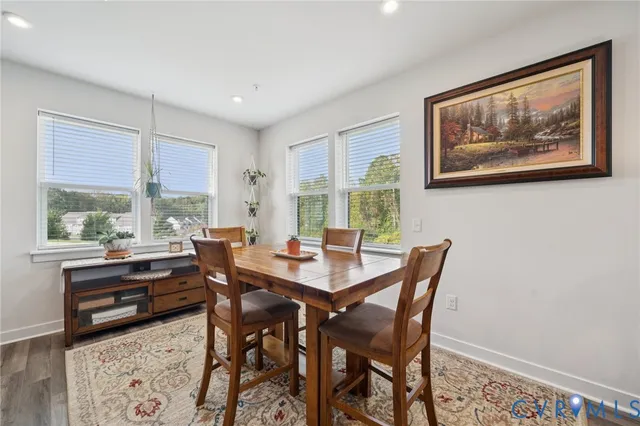 a kitchen with stainless steel appliances kitchen island granite countertop a sink a stove a refrigerator cabinets and chairs