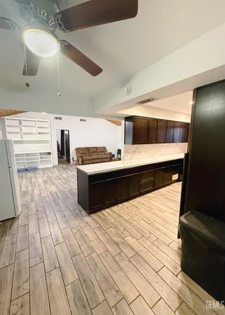 a kitchen with granite countertop a refrigerator and a stove top oven