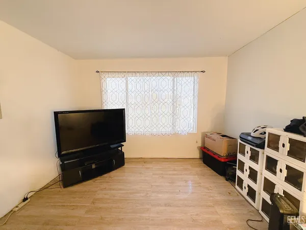 a bedroom with a bed and a flat tv screen on the dresser