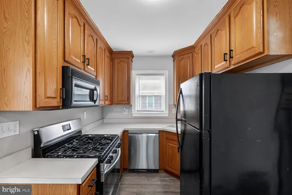 a kitchen with stainless steel appliances granite countertop a refrigerator a stove and a sink