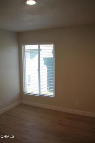 an empty room with wooden floor and closet