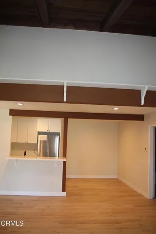 a view of room and kitchen with a refrigerator