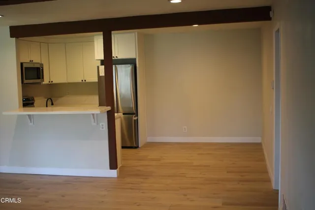 a view of a kitchen with a refrigerator and a sink