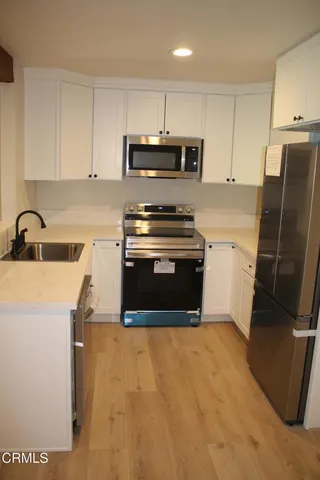 a kitchen with stainless steel appliances granite countertop a stove a sink and a refrigerator