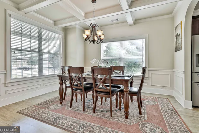 a view of a dining room with furniture wooden floor and chandelier