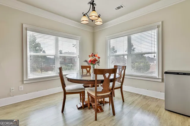 a view of a hallway with wooden floor and a bathroom