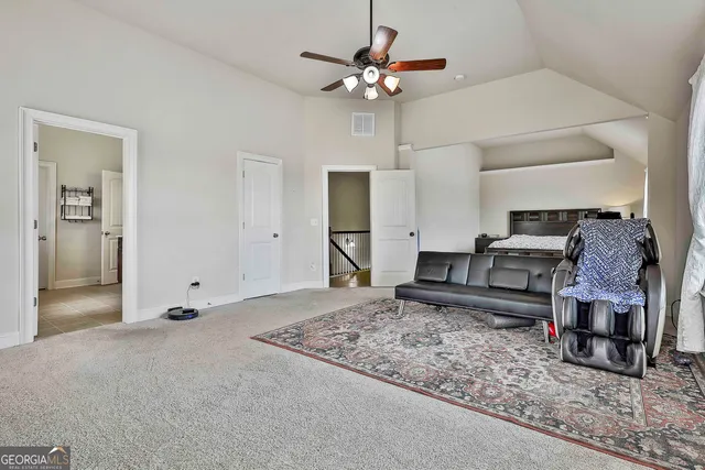 a large bed sitting in a bedroom next to a window with potted plants