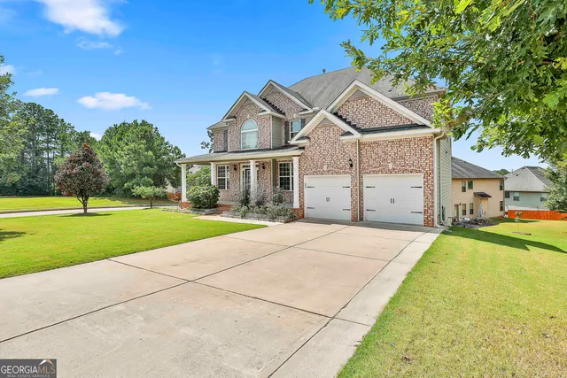a view of a house with a swimming pool and a yard