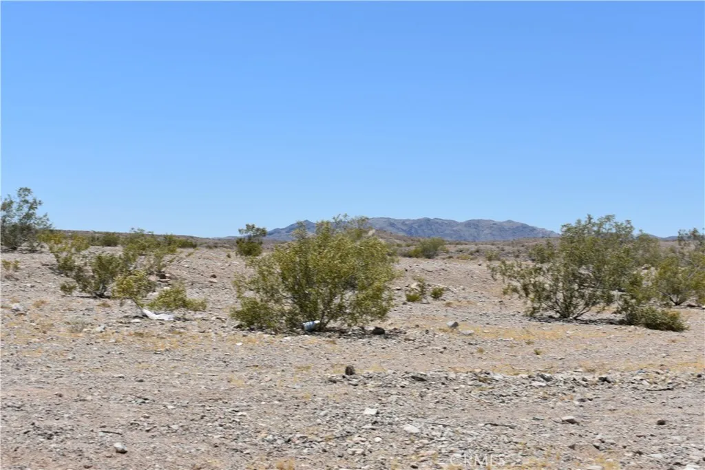 0 Calle Hernandez Road Needles, CA 92363 - Photo 4 of 29 a view of a dry yard with mountains in the background