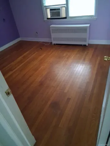 a view of a room with wooden floor and a window