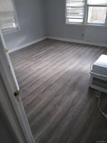 a room with wooden floor and windows