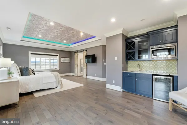 a bedroom with a large bed and wooden floor